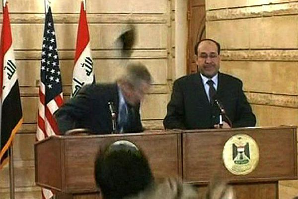 At a press conference with  Iraqi Prime Minister Nouri al-Maliki, President Bush ducks a shoe-throwing journalist.
